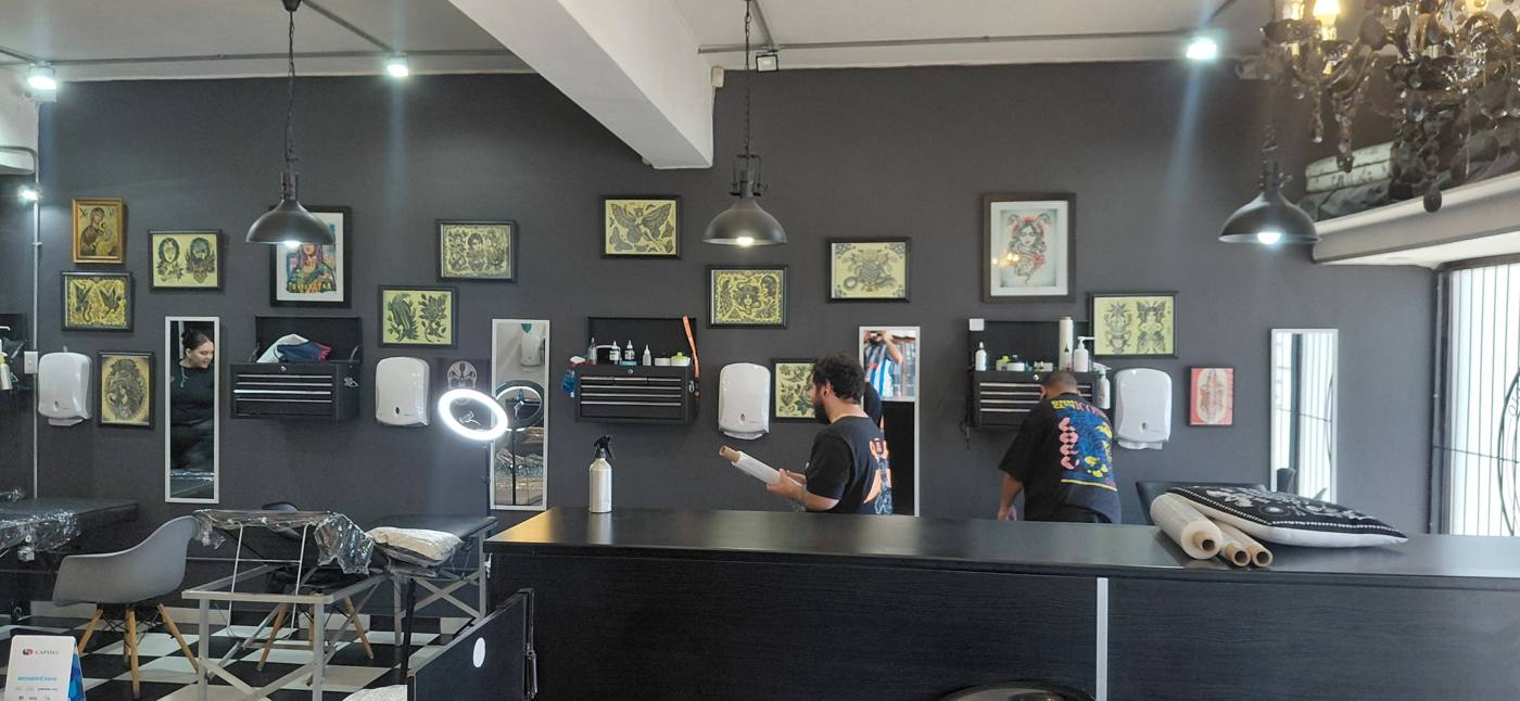 Three tattoo stations along the flash wall, with the counter in front